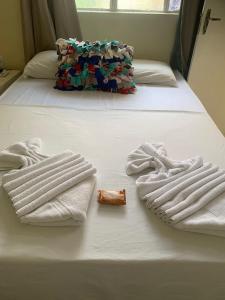 two towels on a bed with a bottle of alcohol at Pousada Maceio Praia in Maceió