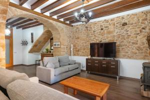een woonkamer met een bank en een tv bij House Ca Na Polida in Alcudia