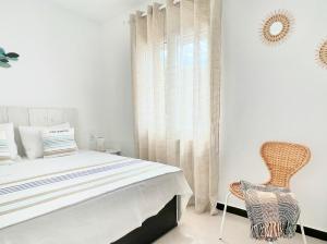 - une chambre avec un lit et une chaise dans l'établissement Apartamento Atardecer en Menorca Son Parc Vista al campo de golf, à Son Parc