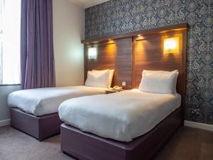 Cette chambre comprend 2 lits et une fenêtre. dans l'établissement Holiday Inn London Oxford Circus, an IHG Hotel, à Londres