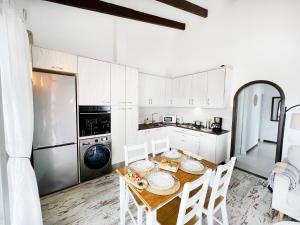 uma cozinha com uma mesa com cadeiras e um frigorífico em Apartamento Atardecer en Menorca Son Parc Vista al campo de golf em Son Parc