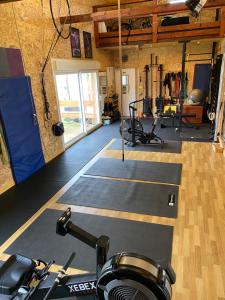 a gym with a bunch of exercise equipment in a room at Love room - love Abella box, location adulte in Saint-Étienne-au-Mont