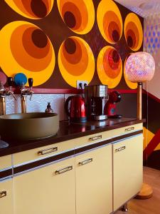 a kitchen with a counter top with a painting on the wall at Love room - love Abella box, location adulte in Saint-Étienne-au-Mont