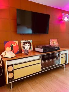 a entertainment center with a tv on a wall at Love room - love Abella box, location adulte in Saint-Étienne-au-Mont +19 photos