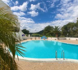 een groot zwembad in een resort bij Apartamento Atardecer en Menorca Son Parc Vista al campo de golf in Son Parc