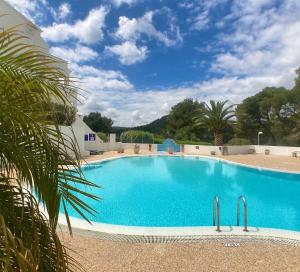a large swimming pool in a resort at Apartamento Atardecer en Menorca Son Parc Vista al campo de golf in Son Parc