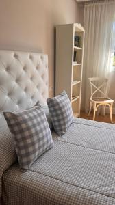 um quarto com uma cama com duas almofadas em BenedettaMolinaseca VuT em Molinaseca