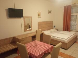 モスタルにあるLovely Home Rooms Centerのベッドとテーブルと椅子のある寝室 +39枚の写真