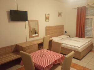 a bedroom with a bed and a table and chairs at Lovely Home Rooms & Apartments in Mostar