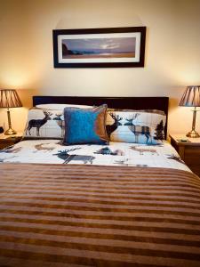 a bedroom with a large bed with two lamps at Grey Stag Apartment in Nairn