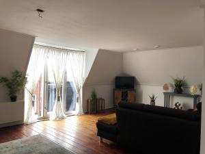 - un salon avec un canapé et une grande fenêtre dans l'établissement B&B Bij Arjan, à Terborg
