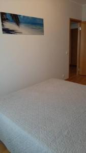 タリンにあるPuhas 2 toaline Kakumäe korterの白いベッドが備わる壁画のあるベッドルームです。