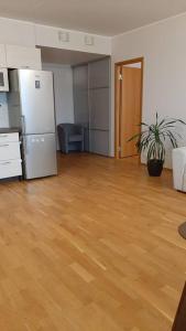 an empty living room with a refrigerator and wooden floors at Puhas 2 toaline Kakumäe korter in Tallinn