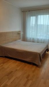 1 cama grande en un dormitorio con ventana en Puhas 2 toaline Kakumäe korter en Tallin