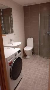 a bathroom with a toilet and a sink and a washing machine at Puhas 2 toaline Kakumäe korter in Tallinn
