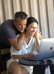 een man en vrouw die naar een laptop kijken bij Casa Santos in Todos Santos
