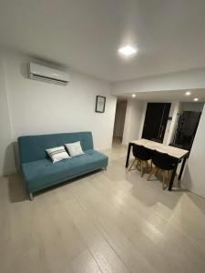 a living room with a blue couch and a table at Nuevo Departamento de categoría de 2 ambientes con cochera y amenities premium en ROYAL PARK Mar del Plata, excelente ubicación a dos cuadras de la playa, para 4 PAX in Mar del Plata
