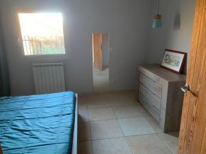 een slaapkamer met een bed, een dressoir en een raam bij Les jonquiers, gîte indépendant cosy avec jardin in Aubagne