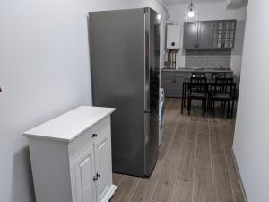 eine Küche mit einem Kühlschrank aus Edelstahl und einem Tisch in der Unterkunft Alina's Deluxe Apartment and free private parking in Dumbrăviţa