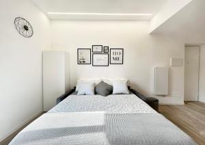 - une chambre blanche avec un grand lit et des oreillers dans l'établissement Casa Vacanza Milano, à Milan