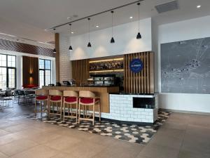 a restaurant with a bar with red stools at Holiday Inn Express - Ankara - Airport by IHG in Ankara