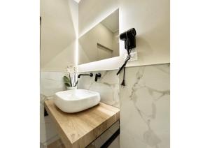 La salle de bains est pourvue d'un lavabo blanc sur un comptoir en bois. dans l'établissement Casa Vacanza Milano, à Milan
