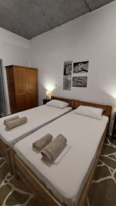 een slaapkamer met twee bedden met handdoeken erop bij Styfilia Beachfront Apartment - Ground Floor in Sifnos