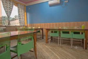a dining room with wooden tables and green chairs at Collection O Dooars Dhaba And Restaurant in Hāsimāra