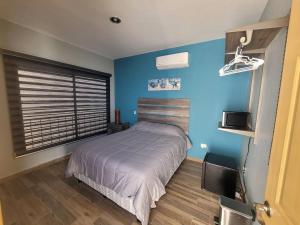a bedroom with a bed and a blue wall at Bring the family to Mazatlán in Mazatlán +11 photos