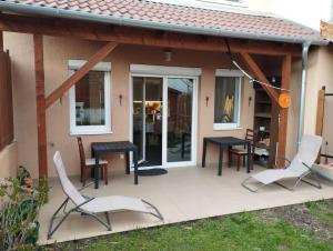 eine Terrasse mit weißen Stühlen sowie einem schwarzen Tisch und Stühlen in der Unterkunft Italia House in Fót