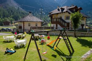 einen Spielplatz mit Schaukel im Hof in der Unterkunft Albergo Rotenthal in Formazza