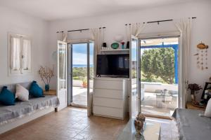 a living room with a couch and a tv at Cycladic home in Paros in Kampos Paros