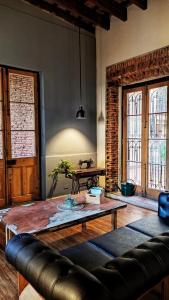 a living room with a leather couch and a table at La Botica de 1852 Hotel in Chascomús