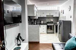 a kitchen with white cabinets and a figurine on a table at Jacky's Home Bolognesi in Huaraz