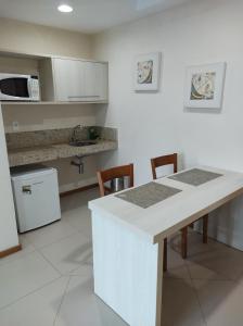 uma cozinha com um balcão branco e uma mesa em Porto Marina Mont Blanc Resort II em Mangaratiba