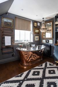 a large copper tub in a bathroom with a rug at The Barth Room at Cheshire Boutique Barns in Nantwich