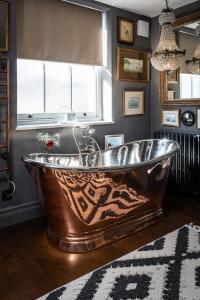 a large copper tub in a bathroom with a window at The Barth Room at Cheshire Boutique Barns in Nantwich