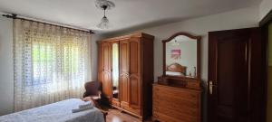 1 dormitorio con tocador, cama y espejo en Villa Teresa con Aparcamiento y Wifi Incluido - Cangas De Onis, en Cangas de Onís