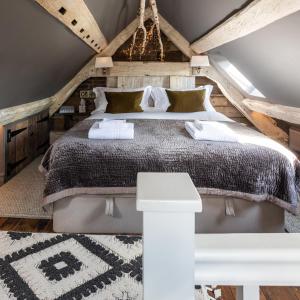 um quarto com uma cama grande num sótão em The Barth Room at Cheshire Boutique Barns em Nantwich