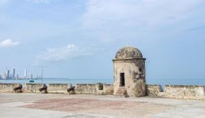 um edifício de pedra ao lado de uma parede ao lado do oceano em 4CB-1 CASA COLONIAL DE 4 HABITACIONES EN EL CENTRO HISTORICO DE CARTAGENA em Cartagena das Índias