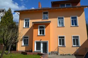 an orange house with white windows at Pension Hubertus in Berlin