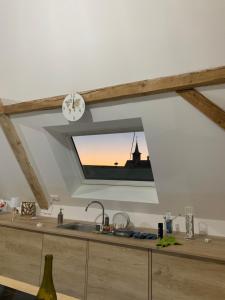 a kitchen with a sink and a clock on the ceiling at Nid de cigogne in Illhaeusern
