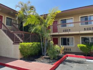 a palm tree in front of a building at Rivera Inn & Suites Motel in Pico Rivera