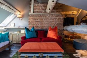 a living room with red couch and colorful pillows at The Cocktail Lounge at Cheshire Boutique Bathhouse in Nantwich