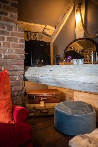 um quarto com uma cama, uma cadeira e bagagem em The Cocktail Lounge at Cheshire Boutique Bathhouse em Nantwich