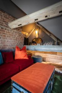 a living room with a red couch and a bar at The Cocktail Lounge at Cheshire Boutique Bathhouse in Nantwich