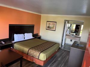 a hotel room with a bed and a bathroom at Rivera Inn & Suites Motel in Pico Rivera