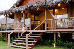 a woman sitting on the stairs of a house at CASA na PRAIA DA BARRINHA Frente Mar in Barrinha