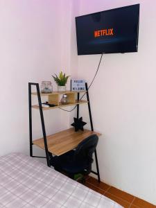Habitación con escritorio, silla y TV. en Hostal Mónaco, en San Miguel