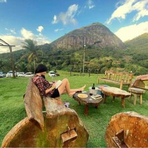 a woman sitting on a bench looking at a mountain at Flat completo do Rodeadouro in Bonito